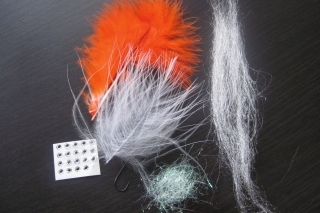 Viazacie materiály: háčik č. 8, biele SLF, biele perie marabou, perleťový dabing, oranžové perie marabou.